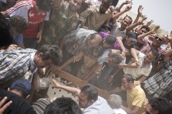 Relatives pour ground on a freshly dug grave as they bury the coffin of one of 7 Libyan rebel fighters killed the day before during the battle for the control of the oil rich town of Brega at the main cemetery in the Libyan rebels stronghold city of Benghazi on July 20, 2011 Relatives pour ground on a freshly dug grave as they bury the coffin of one of 7 Libyan rebel fighters killed the day before during the battle for the control of the oil rich town of Brega at the main cemetery in the Libyan rebels stronghold city of Benghazi on July 20, 2011
