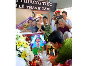 A police officer offers an incense stick at the funeral of Le Thanh Tam, who was killed while chasing robbers Tuesday A police officer offers an incense stick at the funeral of Le Thanh Tam, who was killed while chasing robbers Tuesday