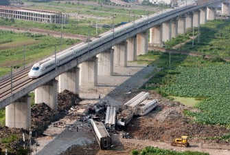 AFP - A bullet train passes the wreckage of two other high-speed trains which collided two days earlier AFP - A bullet train passes the wreckage of two other high-speed trains which collided two days earlier