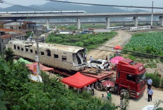 The wreckage of high-speed train carriage is carried on a truck, two days after a fatal collision, in Shuangyu, on the outskirts of Wenzhou in the eastern Chinese province of Zhejiang, on July 26, 2011 The wreckage of high-speed train carriage is carried on a truck, two days after a fatal collision, in Shuangyu, on the outskirts of Wenzhou in the eastern Chinese province of Zhejiang, on July 26, 2011