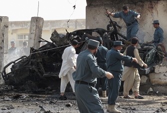 Afghan policemen inspect the site of a suicide car bombing in front of the police chief's office in the southern city of Lashkar Gah in Helmand province on July 31, 2011. Afghan policemen inspect the site of a suicide car bombing in front of the police chief's office in the southern city of Lashkar Gah in Helmand province on July 31, 2011.