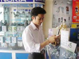 A man uses a low-cost cell phone at a mobile phone shop in HCMC (Photo: Minh Tri) A man uses a low-cost cell phone at a mobile phone shop in HCMC (Photo: Minh Tri)