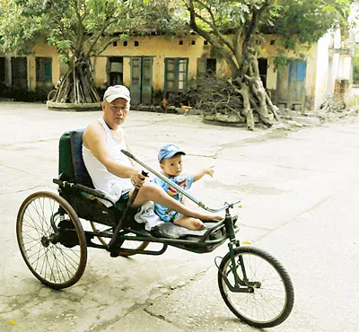 Thương binh Ngô Văn Thịnh ngày ngày cùng cháu nội đi dạo trên xe lăn