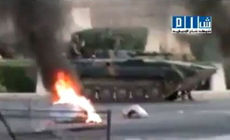 An image grab from a video uploaded on YouTube shows a Syrian army tank driving past burning tires in the city of Hama on July 31, 2011. AFP PHOTO/YOU TUBE An image grab from a video uploaded on YouTube shows a Syrian army tank driving past burning tires in the city of Hama on July 31, 2011. AFP PHOTO/YOU TUBE