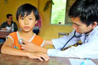 Volunteer doctor examines a child in Binh Hoa Bac ward in district Duc Hue in Long An province (Photo: SGGP) Volunteer doctor examines a child in Binh Hoa Bac ward in district Duc Hue in Long An province (Photo: SGGP)