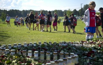 AFP - A Norway cup soccer player pays his last respect at a makeshift memorial alongside the football pitches for the victims AFP - A Norway cup soccer player pays his last respect at a makeshift memorial alongside the football pitches for the victims