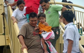 A man carries a child rescued from the 2,400-tonne MV Trans Asia Malaysia, a passenger and cargo ship, that was hit by strong waves causing it to lean over and sink at the coast of Ajuy, in Iloilo, the central Philippines on July 31, 2011. A man carries a child rescued from the 2,400-tonne MV Trans Asia Malaysia, a passenger and cargo ship, that was hit by strong waves causing it to lean over and sink at the coast of Ajuy, in Iloilo, the central Philippines on July 31, 2011.