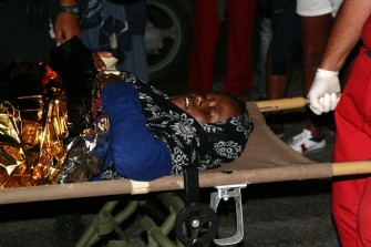 A woman is carried on a stretcher in Lampedusa on August 4, 2011 A woman is carried on a stretcher in Lampedusa on August 4, 2011