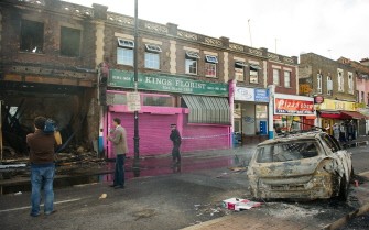AFP - A police officer sets up a cordon around a burnt-out shop on High Road in Tottenham AFP - A police officer sets up a cordon around a burnt-out shop on High Road in Tottenham