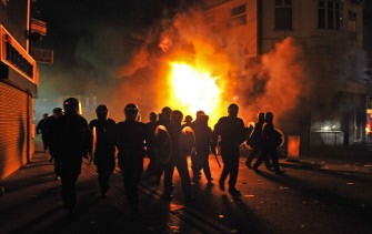 AFP - British riot police arrive in front of a burning building in Croydon, South London on August 8, 2011 AFP - British riot police arrive in front of a burning building in Croydon, South London on August 8, 2011