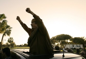 (AFP FILES) A picture taken on April 10, 2011 shows Libyan leader Moamer Kadhafi gesturing at his supporters outside his Bab al-Aziziya residence after his meeting with African leaders in Tripoli (AFP FILES) A picture taken on April 10, 2011 shows Libyan leader Moamer Kadhafi gesturing at his supporters outside his Bab al-Aziziya residence after his meeting with African leaders in Tripoli