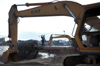 AFP - A Cambodian worker (C) stands on a pipe pumping sand into the Boeung Kak lake in central Phnom Penh on August 16, 2011 AFP - A Cambodian worker (C) stands on a pipe pumping sand into the Boeung Kak lake in central Phnom Penh on August 16, 2011