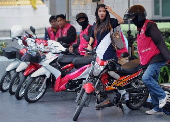 AFP - This photo taken on July 28, 2011 shows a Thai office worker (2nd R) negotiating for a motorbike taxi ride for transport in Bangkok. They zip through the traffic-choked streets of Bangkok. AFP - This photo taken on July 28, 2011 shows a Thai office worker (2nd R) negotiating for a motorbike taxi ride for transport in Bangkok. They zip through the traffic-choked streets of Bangkok.