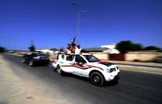 Libyan rebels raise their guns in celebration as they drive through the main road leading to Zawiya, some 40 kms west of Tripoli, on August 20, 2011 Libyan rebels raise their guns in celebration as they drive through the main road leading to Zawiya, some 40 kms west of Tripoli, on August 20, 2011