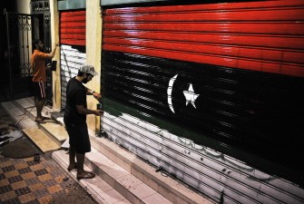 AFP- A man paints the Libyan flag on a door in Zuwara, West Libya on August 26, 2011 AFP- A man paints the Libyan flag on a door in Zuwara, West Libya on August 26, 2011