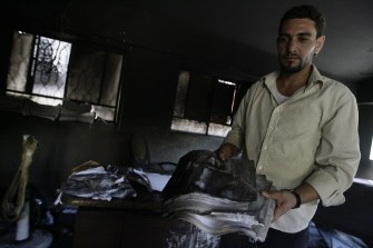A Syrian employee inspects his burnt office at the courthouse of Duma, a suburb northeast of the capital Damascus on August 29, 2011 A Syrian employee inspects his burnt office at the courthouse of Duma, a suburb northeast of the capital Damascus on August 29, 2011
