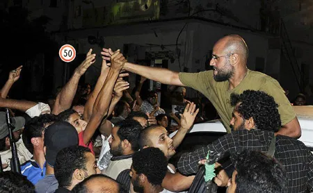 Saif al-Islam tươi cười bắt tay với những người ủng hộ. Ảnh: Xinhua Saif al-Islam tươi cười bắt tay với những người ủng hộ. Ảnh: Xinhua