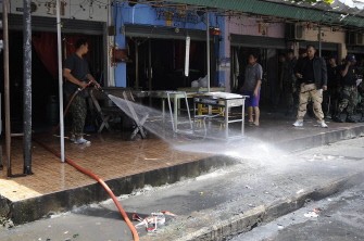AFP - Thai official workers clean the site of a bomb blast by suspected separatist militants in Thailand's restive southern province of Narathiwat on September 17, 2011. AFP - Thai official workers clean the site of a bomb blast by suspected separatist militants in Thailand's restive southern province of Narathiwat on September 17, 2011.