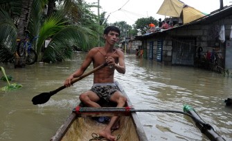 A man rows a boat along a flooded street after the passage of Typhoon Nesat in Pulilan, north of Manila on October 1, 2011. A man rows a boat along a flooded street after the passage of Typhoon Nesat in Pulilan, north of Manila on October 1, 2011.