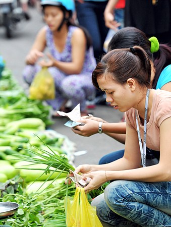 Workers buying vegetables at a street market in HCM city Workers buying vegetables at a street market in HCM city