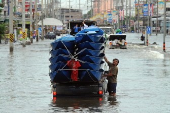 AFP - A Thai man secures his boats on a truck along a flooded street in Pathum Thani province, suburban Bangkok, on October 14, 2011. AFP - A Thai man secures his boats on a truck along a flooded street in Pathum Thani province, suburban Bangkok, on October 14, 2011.