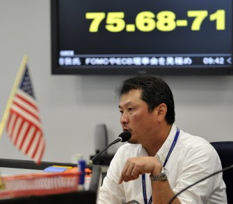 A currency dealer calls an order before a foreign exchange rate board at a foreign exchange market in Tokyo on October 31, 2011. A currency dealer calls an order before a foreign exchange rate board at a foreign exchange market in Tokyo on October 31, 2011.