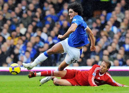 Tiền vệ Marouane Fellaini (Everton) cố thoát qua sự truy cản của Lucas (Liverpool)