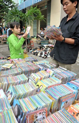 Công nhân chọn mua CD vỉa hè để giải trí sau giờ làm. Công nhân chọn mua CD vỉa hè để giải trí sau giờ làm.