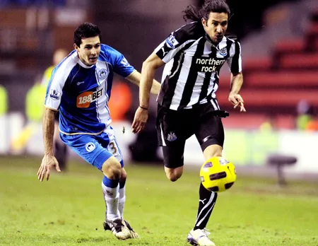 Tiền vệ Jonas Gutierrez (phải, Newcastle) đi bóng trước hậu vệ Antolin Alcaraz (Wigan).