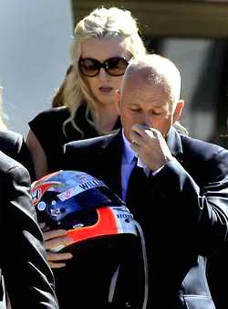 Bố của Dan Wheldon cầm chiếc mũ thi đấu.