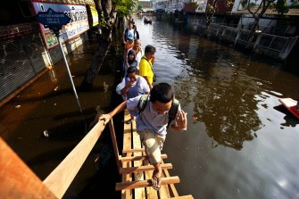 AFP - Local residents use a wooded footbridge to walk down a flooded street in Bangkok on November 19, 2011. AFP - Local residents use a wooded footbridge to walk down a flooded street in Bangkok on November 19, 2011.