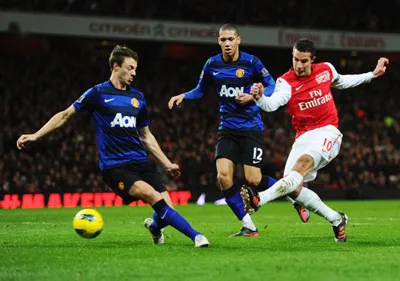 Tiền đạo Robin van Persie (phải, Arsenal) nỗ lực tung cú sút trước hàng phòng ngự Man. United. Tiền đạo Robin van Persie (phải, Arsenal) nỗ lực tung cú sút trước hàng phòng ngự Man. United.