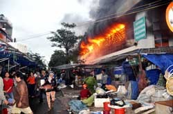 People evacuate goods from their temporary stalls while fire fighters attempt to reach a blaze at Quang Ngai City Market (Photo:VNA) People evacuate goods from their temporary stalls while fire fighters attempt to reach a blaze at Quang Ngai City Market (Photo:VNA)