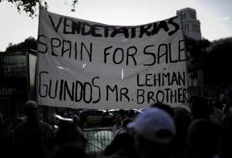 A man holds a banner during a protest against the request of financial support from the European Union by the Spanish government in front of a Bank of Spain building on June 11, 2012 in Barcelona. A man holds a banner during a protest against the request of financial support from the European Union by the Spanish government in front of a Bank of Spain building on June 11, 2012 in Barcelona.