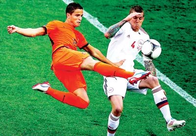 Hậu vệ Daniel Agger (Đan Mạch) cố gắng chặn cú sút của Ibrahim Afellay (Hà Lan).