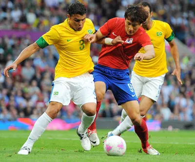 Trung vệ Thiago Silva (trái, Brazil) tranh bóng với Ji Dong-won của Hàn Quốc.