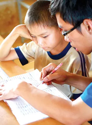 Kiên trì dạy em nhỏ học bài. Ảnh: Phạm Vũ Hoàng Giang Kiên trì dạy em nhỏ học bài. Ảnh: Phạm Vũ Hoàng Giang