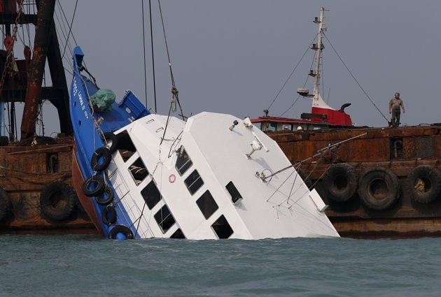 Officials check on a half submerged boat after it collided Monday night near Lamma Island, off the southwestern coast of Hong Kong Island Tuesday Oct. 2, 2012. Officials check on a half submerged boat after it collided Monday night near Lamma Island, off the southwestern coast of Hong Kong Island Tuesday Oct. 2, 2012.
