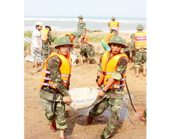 Border armed forces help residents fortify the dyke system to cope with high tide in Tuy An District (Photo: SGGP) Border armed forces help residents fortify the dyke system to cope with high tide in Tuy An District (Photo: SGGP)