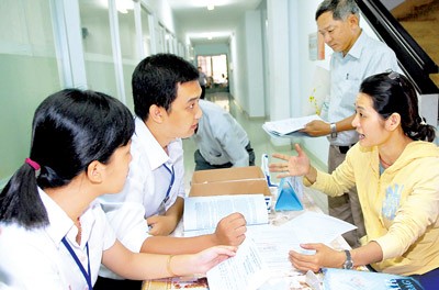 Staff of the HCMC Taxation Department (L) answers queries of business people (Photo: SGGP) Staff of the HCMC Taxation Department (L) answers queries of business people (Photo: SGGP)