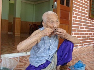 An elderly woman chewing betel leaf with areca nut An elderly woman chewing betel leaf with areca nut