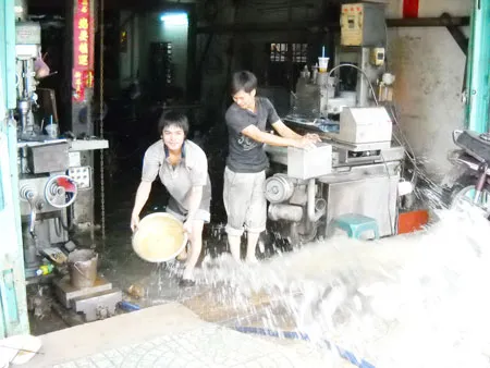Một sơ sở cơ khí trên đường Nguyễn Văn Luông, quận 6 bị ngập, nhân viên phải dùng thau tát nước ra ngoài. Một sơ sở cơ khí trên đường Nguyễn Văn Luông, quận 6 bị ngập, nhân viên phải dùng thau tát nước ra ngoài.