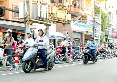 Người điều khiển xe hai bánh dừng chờ đèn đỏ bên ngoài dải phân cách trên đường Huỳnh Văn Bánh, quận Phú Nhuận. Người điều khiển xe hai bánh dừng chờ đèn đỏ bên ngoài dải phân cách trên đường Huỳnh Văn Bánh, quận Phú Nhuận.