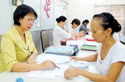 A staff of the People’s Committee in Nguyen Cu Trinh Ward guides a resident to complete paper formalities (Photo: SGGP) A staff of the People’s Committee in Nguyen Cu Trinh Ward guides a resident to complete paper formalities (Photo: SGGP)