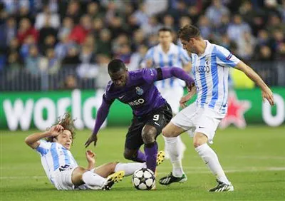Jackson Martinez (áo sậm, Porto) trong vòng vây của Manuel Iturra (trái) và đội trưởng Joaquin Sanchez bên phía Malaga. Jackson Martinez (áo sậm, Porto) trong vòng vây của Manuel Iturra (trái) và đội trưởng Joaquin Sanchez bên phía Malaga.