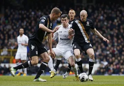 Tiền vệ Gareth Bale (áo trắng, Tottenham) bế tắc trong vòng vây của các cầu thủ Fulham.