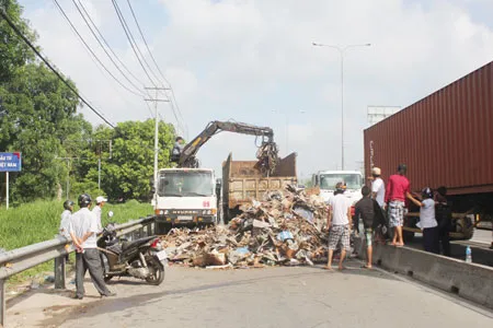 Xe tải lật nhào, hàng chục tấn phế liệu vương vãi khắp đường