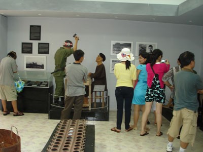 Tourists take photos and watch pictures to display activties of prisoners in Phu Quoc prison in war time (Photo: Cat Tuong ) Tourists take photos and watch pictures to display activties of prisoners in Phu Quoc prison in war time (Photo: Cat Tuong )