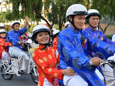 The 100 grooms drive their brides on electric bicycles along the streets to call for environmental protection, dressed in traditional ‘Ao Dai’ (Vietnamese long dress) and ‘Khan Dong’ (Vietnamese turban) The 100 grooms drive their brides on electric bicycles along the streets to call for environmental protection, dressed in traditional ‘Ao Dai’ (Vietnamese long dress) and ‘Khan Dong’ (Vietnamese turban)