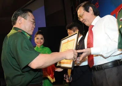 Đại diện Bộ Tư lệnh Bộ đội biên phòng trao tặng bằng khen cho ông Nguyễn Tấn Phong, Tổng Biên tập Báo SGGP. Ảnh: Cao Thăng